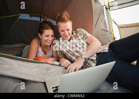 La Svizzera, Leysin, gli escursionisti in tenda utilizzando laptop Foto Stock