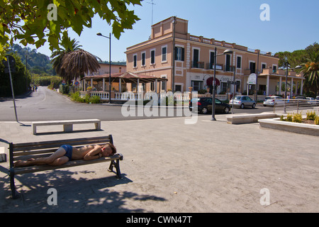 Giovane uomo addormentato sul banco in Lago di Bracciano fi a metà agosto Italia Foto Stock