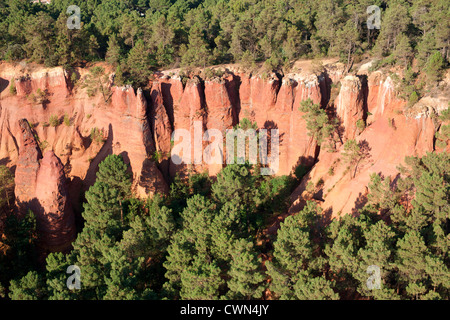 VISTA AEREA. Scogliere di argilla ocra rossa. Roussillon, Lubéron, Vaucluse, Provenza, Francia. Foto Stock