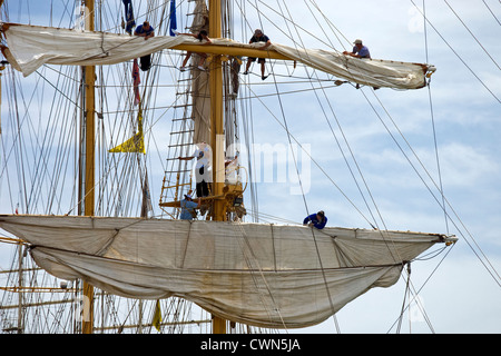 Marinai di issare le vele di una vecchia nave a vela nel porto della città di Volos (Tessaglia, Grecia) Foto Stock