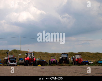 I vecchi trattori usati dai pescatori per tirare le barche al di fuori del mare, Caister-on-Sea, Norfolk, Regno Unito Foto Stock