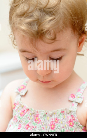 Bambina guardando verso il basso Foto Stock