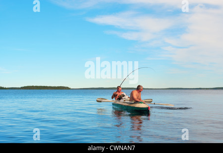 Due turisti-pescatori hanno catturato un pike sul lago blu Foto Stock