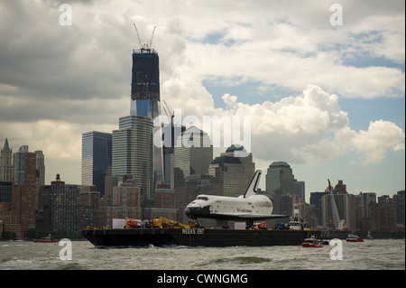 Lo space shuttle Enterprise è trainato da includersi fino al Fiume Hudson a New York con il World Trade Center's Freedom Tower in background Giugno 6, 2012 mentre su di esso in un'Intrepid Sea, il Museo dell'aria e dello spazio. Foto Stock