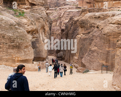 Petra e storico sito archeologico in Giordania gruppo di tour all'ingresso al Siq il canyon che conduce al sito principale Foto Stock