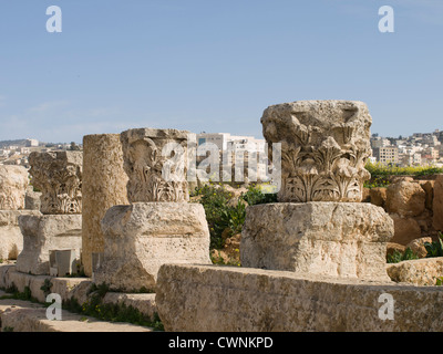 Le rovine della città romana di Gerasa in oggi Jerash in Giordania, parti di colonne nei pressi del ninfeo con moderna città sullo sfondo Foto Stock