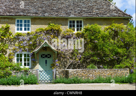 Tradizionale pietra di Cotswold wysteria-placcati cottage nel pittoresco villaggio di Eastleach Turville in Cotswolds, Gloucestershire, Regno Unito Foto Stock