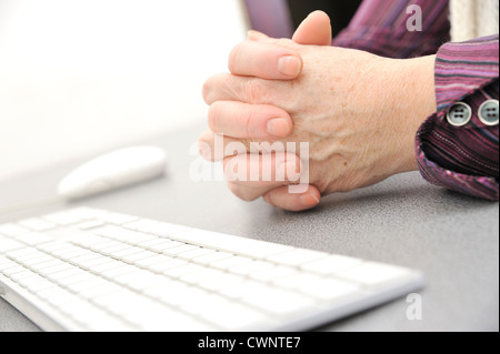 Le mani di una vecchia donna digitando sulla tastiera, isolato su bianco, close-up. Foto Stock