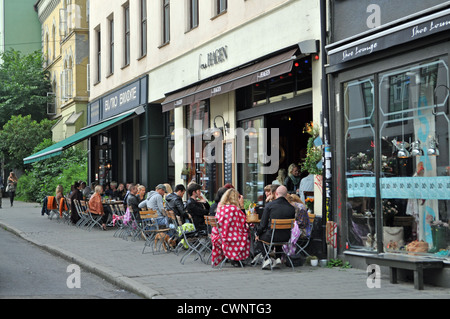Cultura del caffè a Oslo: Qui, le persone che siedono nei caffè del marciapiede in una serata estiva sulla porta Thorvald Meyers nella zona alla moda di Grunerlokka. Foto Stock