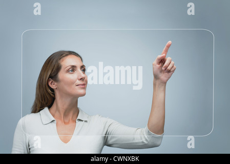 Donna con un grande touch screen trasparente Foto Stock