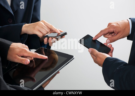 I colleghi lo scambio di informazioni con gli smartphone e tablet digitale, ritagliato Foto Stock