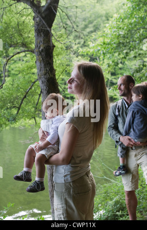 Famiglia di boschi guardando il fiume, focus su azienda madre bambina Foto Stock