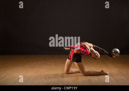 Ginnasta flessione all'indietro tenendo palla Foto Stock