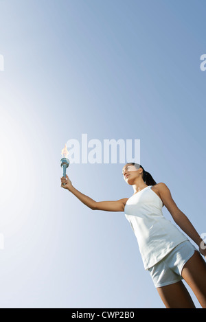 Atleta femminile tenendo in mano la torcia a basso angolo di visione Foto Stock