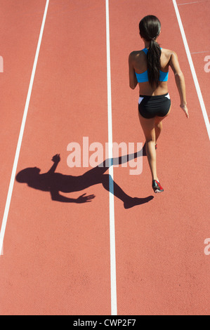 Atleta femminile in esecuzione su pista, vista posteriore Foto Stock