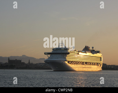 Cunard Line nave da crociera "Azura" arrivando alla mattina presto nel porto di Palma de Mallorca - con Palma storica cattedrale Foto Stock