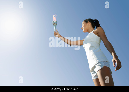 Atleta femminile tenendo in mano la torcia a basso angolo di visione Foto Stock