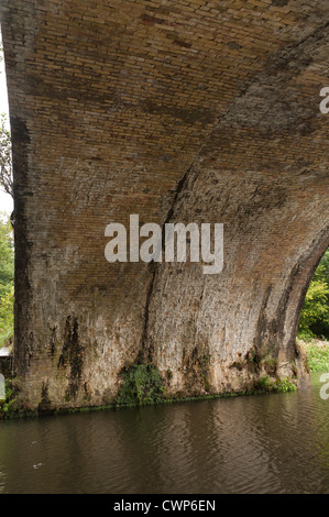La pioggia e l'acqua danni trafili attraverso in mattoni in stile vittoriano ponte ferroviario lasciando acqua dura calcificazione di deposito di calcare di scala Foto Stock