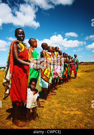 Gli uomini africani balli all'aperto, tribale uomo indossando variopinti costumi nazionali, il Masai Mara, Kenya, folk tradizionale danza maschi Foto Stock