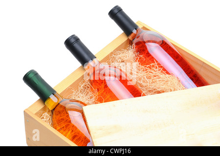 Primo piano di tre arrossire le bottiglie di vino sul loro lato in una cassa di legno. Foto Stock