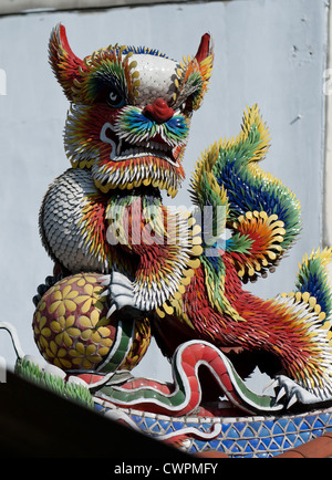 La scultura di stile Cinese lion tenendo una palla sul tetto di un tempio taoista in Sanxia vicino a Taipei, Taiwan Foto Stock