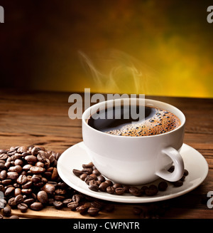 Tazza da caffè con piattino su un tavolo di legno. Sfondo scuro. Foto Stock