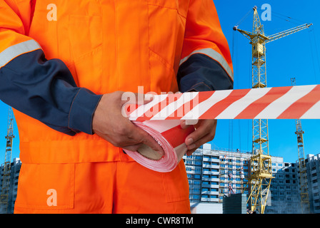 Lavoratore tratto di nastro di avvertimento sulla costruzione di sfondo Foto Stock