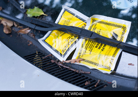 Due biglietti di parcheggio attaccata al finestrino di un'automobile a Londra REGNO UNITO. La vettura sembra essere stato per qualche tempo. Foto Stock