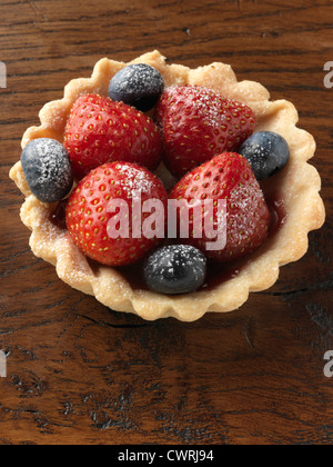 Singoli berry crostata di fragole e mirtilli su uno sfondo di legno Foto Stock