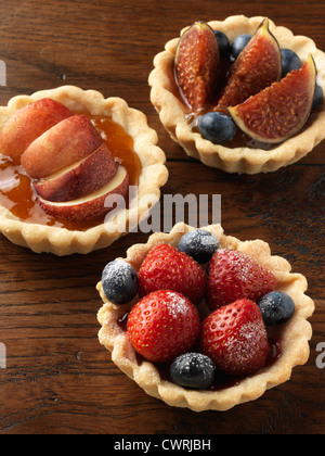 Fig tart, pesche noci crostata e berry tart su uno sfondo di legno Foto Stock