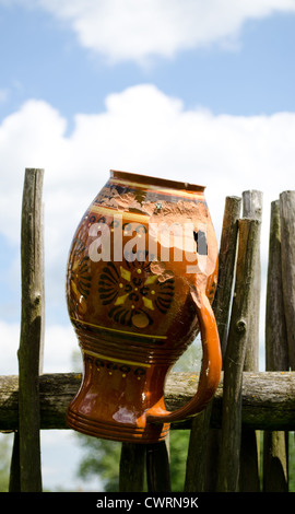 Argilla brocca rotta pende sulla staccionata in legno da tessuti a rami di alberi. Foto Stock