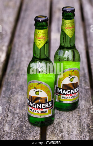 Bottiglie di Magners sidro di pere su di un tavolo di legno. Foto Stock