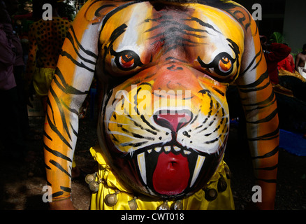 Tiger faccia su Body Art dal ballerino Pulikali stomaco pancia in Onam celebrazioni a Kerala India.ricreativo Indian folk arts Foto Stock