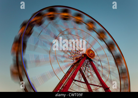 Il colorfully illuminato Gentle Giant Ferris Wheel gira contro il cielo al crepuscolo durante il New Jersey State Fair. Foto Stock