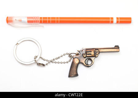 Pistola giocattolo con portachiavi e penna isolati su sfondo bianco Foto Stock