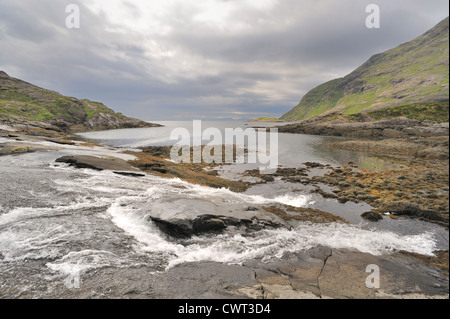 Veloce che scorre il fiume incontra il mare con la bassa marea Foto Stock