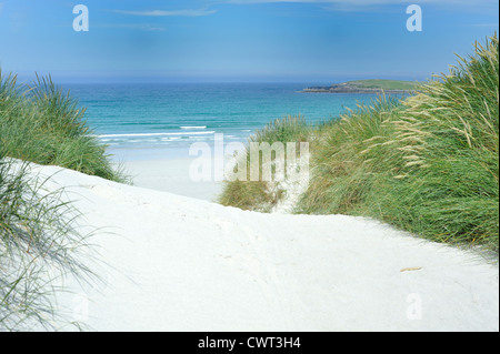 Vista attraverso machair attraverso white sandunes conduce ad una spiaggia deserta Foto Stock