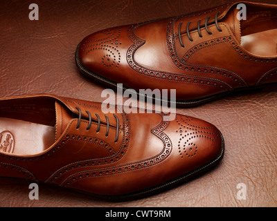 Costoso di lusso in pelle marrone scarpe brogue su una pelle vintage valigia Foto Stock