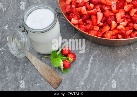 Le fragole in jam fabbricante i con lo zucchero e i vasetti per la produzione di marmellate Foto Stock