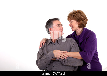 Una coppia matura affettuosamente tenere ogni altro e sorriso amorevolmente ad uno un altro. Foto Stock