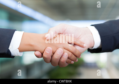 L uomo e la donna si stringono la mano in ufficio Foto Stock