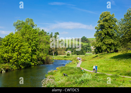La gente camminare lungo il fiume Wye a Bakewell Derbyshire Parco Nazionale di Peak District Inghilterra UK GB EU Europe Foto Stock