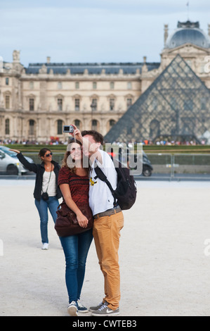 Parigi, Francia - giovane coppia di turisti che visitano la città e scattare foto di se stessi per il museo del Louvre Foto Stock