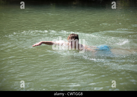 Giovane uomo nuotare nel fiume Isar, Monaco di Baviera, Germania Foto Stock