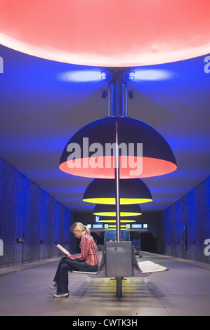 Giovane donna libro di lettura nella stazione della metropolitana Foto Stock