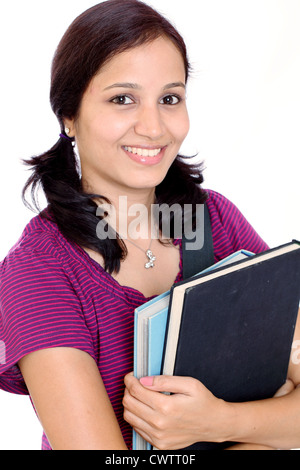 Indiano sorridente studentessa azienda libri contro uno sfondo bianco Foto Stock