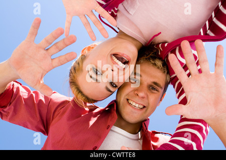 Coppia giovane guardando in giù con le loro teste insieme e divertirsi sulla spiaggia Foto Stock