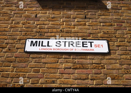 Cartello stradale su un muro di mattoni per Mill Street a Southwark. Londra. Vicino al Tower Bridge Foto Stock