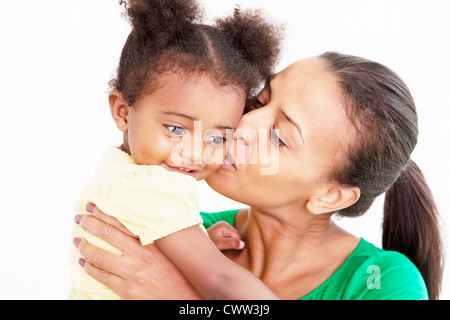 Madre e figlia baciare in cucina Foto Stock