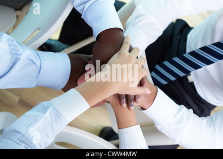 Al di sopra di vista business partner per le mani sulla parte superiore di ogni altra compagnia di simbolizzazione e unità Foto Stock